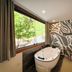 Velinn Pousada Canoa Ilhabela bathroom with soaking tub, large window and zebra-patterned wall