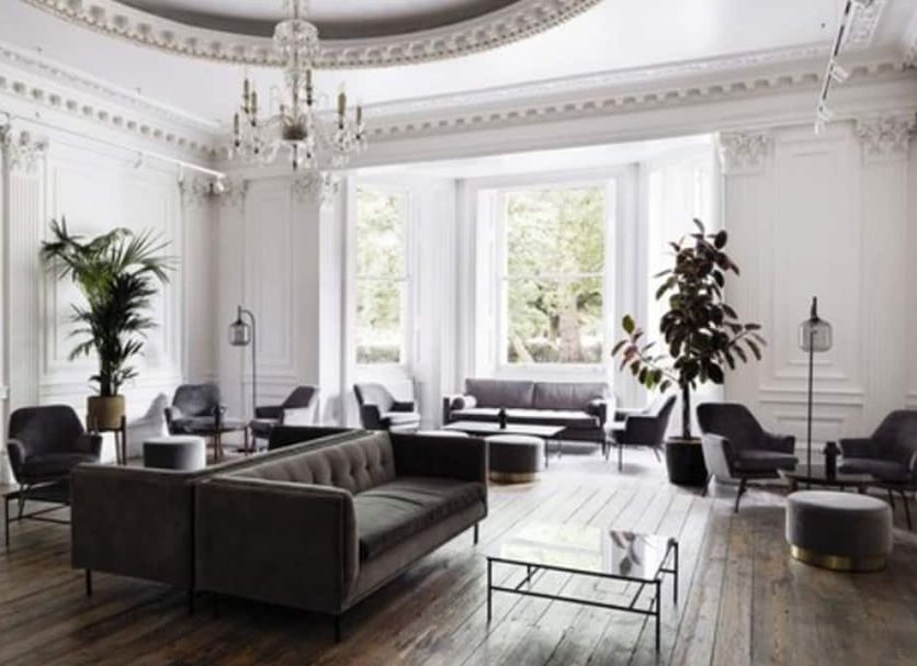 The Columbia London lounge with leather seating, chandeliers, and tall windows