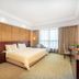 Chinflux Mandarin Hotel in Dongguan guest room with king bed, large window, desk and wall-mounted TV