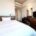 Hotel Route-Inn Iwaki Ekimae guest room with bed, desk, mirror and TV in Iwaki