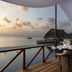 Anantara Dhigu Maldives Resort deck dining area with ocean view and sunset over the water in Dhigufinolhu