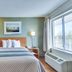 HomeTowne Studios by Red Roof Austin guest room with bed, window view, and bedside lamp