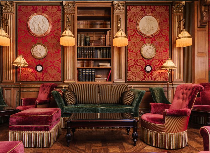 Château de Courcelles - Relais & Châteaux lounge with velvet chairs and ornate red walls in Courcelles-sur-Vesle