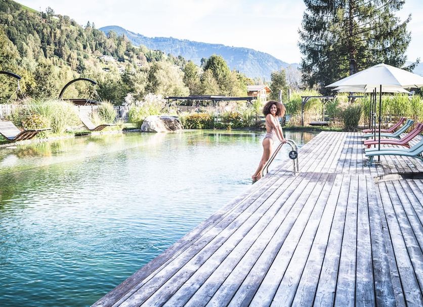 Hotel Das Falkenstein in Kaprun: outdoor pool with mountain views and sun loungers