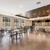 Four Points by Sheraton Elkhart lobby lounge with tables, chairs and large windows in Elkhart