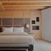 Aman Rosa Alpina bedroom in Badia/Abtei with wood-paneled walls and a king bed
