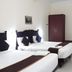 Hotel Temple Citi Kanyakumari twin room with two beds, wardrobe, wall art and bright white interiors