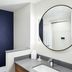 Fairfield Inn & Suites by Marriott Sheboygan bathroom vanity with round mirror and navy accent wall