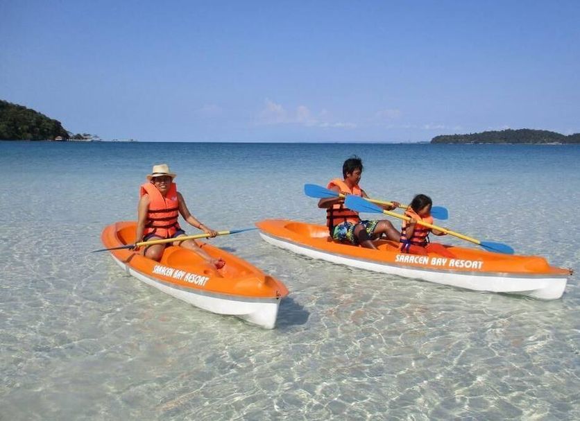 Saracen Bay Resort, Koh Rong Sanloem: guests kayak in clear shallow sea with distant islands