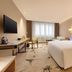 Guanganmen Grand Metropark Hotel Beijing guest room with king bed, desk, lounge chair and large window in Beijing