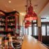 Hotel & Restaurant Goldener Pflug, Ludwigsburg: warm-lit bar with shelves of bottles and hanging copper lamps