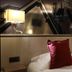 La Confiance in Le Mont-Saint-Michel guest room with twin bed, red pillows and wall lamps