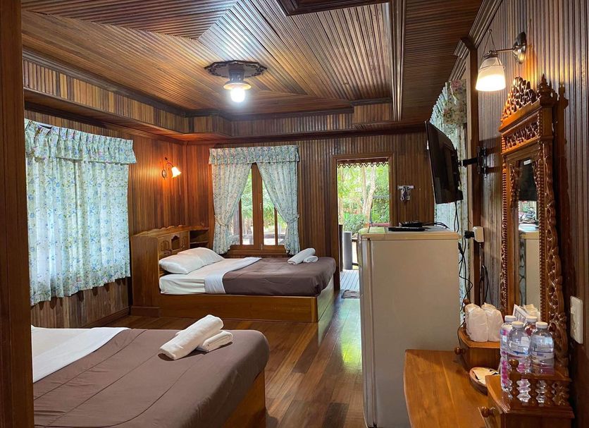 Sri Phairin Resort in Chanthaburi guest room with two beds, wood-paneled walls, and balcony doors