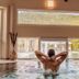 Schlössl Hotel Kindl indoor pool with a guest relaxing and hillside views in Bad Gleichenberg