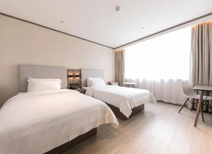 Hanting Hotel Hangzhou Zhaohui Road room with two twin beds and a bright window in Hangzhou