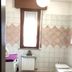 Casa Perlar Verona bathroom with window, tiled walls, washing machine, sink and toilet
