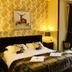 Lairds Lodge Inverness guest room with king bed, deer artwork, bedside lamps and window seating area