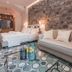 Médousa Suites in Taormina, stylish suite with stone wall, sofa, bed and patterned tile floor