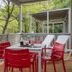 Outdoor terrace seating at hu I Pini village in Fiano Romano with red and white chairs