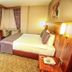 Adana Garden Business Hotel room in Adana with bed, desk, mirror, and seating area