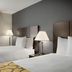 Baymont by Wyndham Branford/New Haven guest room with two beds and bedside lamps in Branford