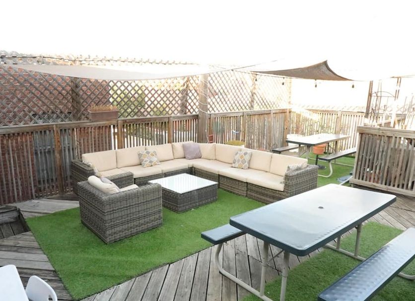 Duo Housing in Washington, D.C. rooftop terrace with sectional seating, tables, and artificial grass