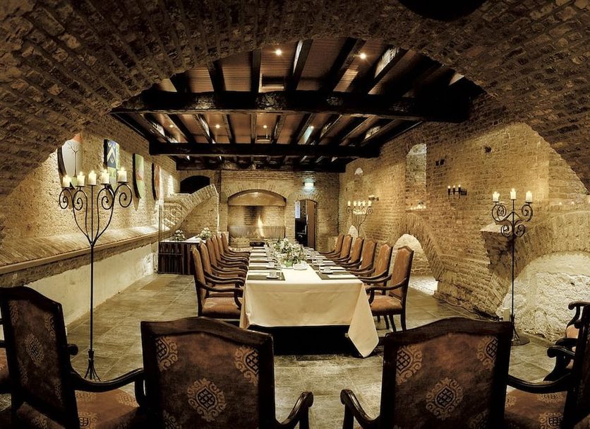 Romantik Hotel Kasteel Daelenbroeck in Herkenbosch wine cellar dining room with long table and vaulted brick arches