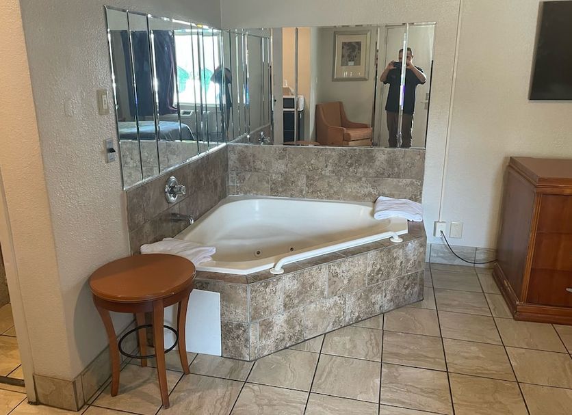 Budgetel Inn and Suites - Louisville bathroom with corner jetted tub and mirrored wall