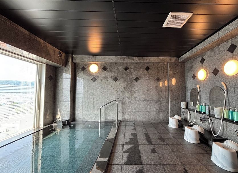Hotel Route-Inn Tokuyama Ekimae indoor hot spring bath in Shunan with tiled pool and shower area