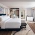 Radisson Hotel Chateau de Bangkok guest room in Bangkok with king bed, TV, sitting bench and city view