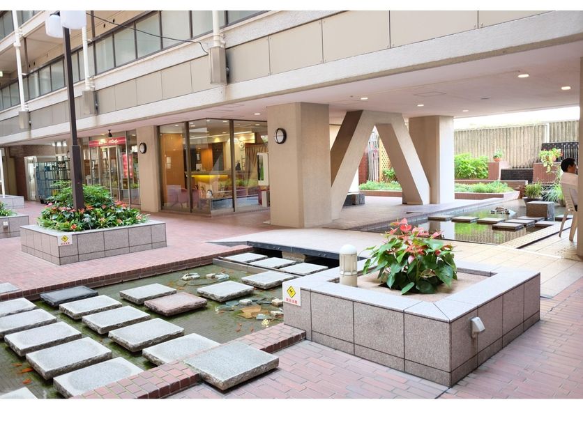 Tokyo Buc Nakagin in Tokyo, courtyard with stepping stones, pond and covered hotel entrance