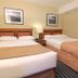 Medicine Hat Suites room in Medicine Hat with two beds, bedside lamp and framed wall art