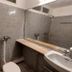 Hotel Sea Coast Digha bathroom with tiled shower area, sink, and large mirror