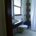 Bathroom at Fabhotel Prime Chennai Deluxe in Chennai with shower, toilet, sink and a window.
