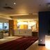 Hampton By Hilton Derby City Centre lobby with front desk, red rug, and illuminated plant in Derby