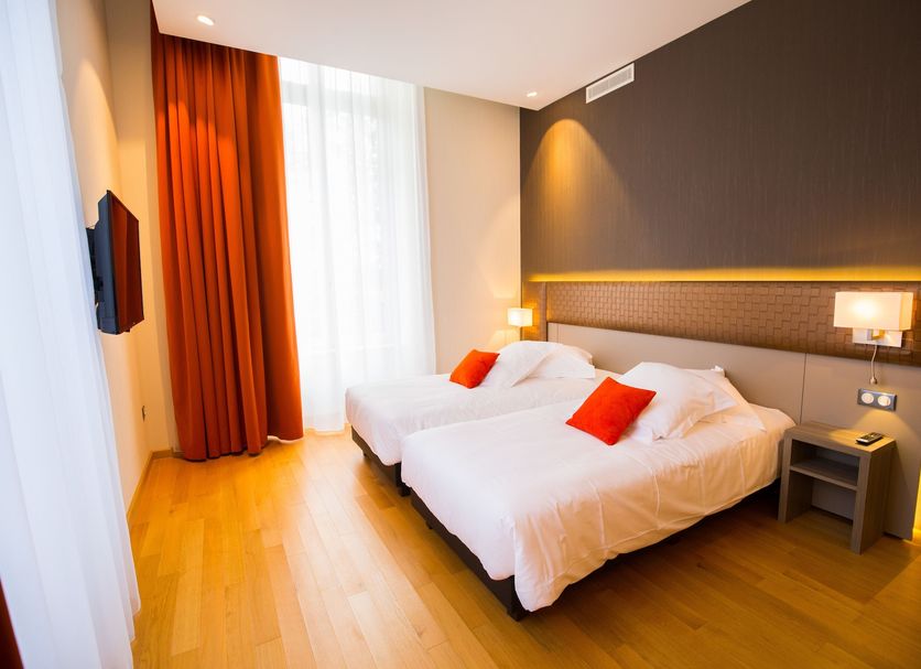 Les Jardins du Mess in Verdun: modern twin room with orange accents and large window