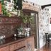 Hotel Marqués de la Moral lobby with carved wooden sideboard, stone wall and potted greenery in Castrillón