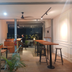 Pinx's Hostel Jakarta lounge with bar stools, high tables and an open view to greenery outside