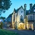 Ashdown Park Hotel & Country Club in East Grinstead, illuminated stone manor exterior at dusk