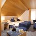 Garni-Hotel Adler in Ostfildern: attic room with double bed, desk, TV and sloped wood ceiling