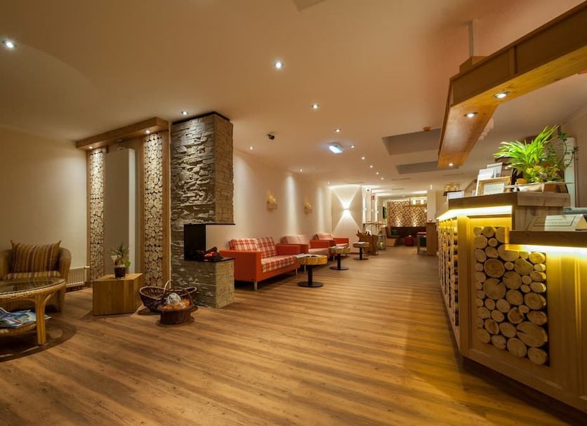 Panoramahotel Kühbergalp lobby lounge in Blaichach with wood floors, seating, and warm ambient lighting