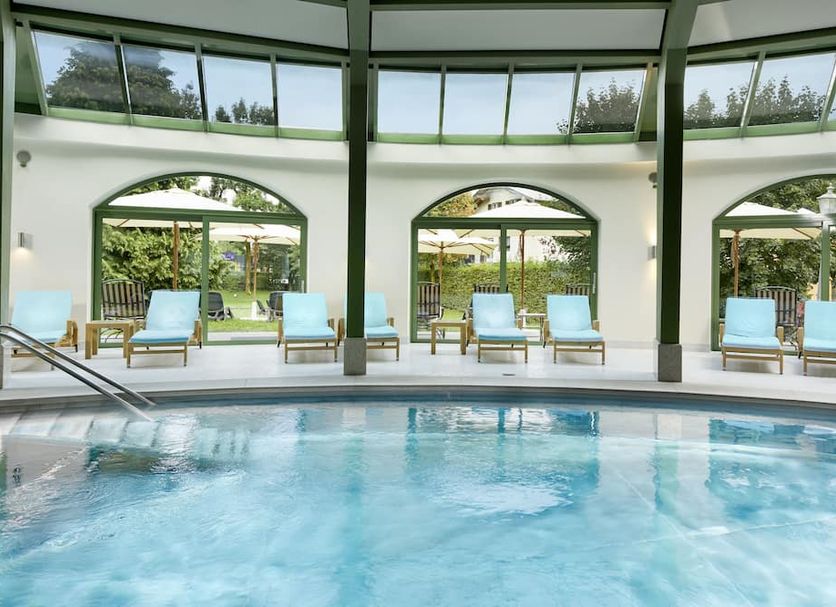 Das Alpenhaus Gasteinertal in Bad Hofgastein indoor pool with lounge chairs and garden views