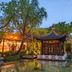 Changle Inn in Yangzhou: traditional pavilion beside a pond at dusk, surrounded by trees and garden lights