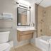 Spark by Hilton Toronto Markham bathroom with tub-shower combo, vanity, and grab bars in Markham