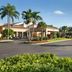 Courtyard by Marriott Fort Myers Cape Coral hotel exterior with palm-lined driveway and landscaped entrance