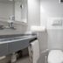 Kyriad Eco Lille Sud - Noyelles Godault bathroom with toilet, sink, mirror, and shower area