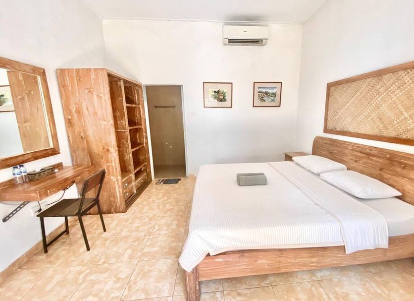 Ashana Hotel South Kuta room with wooden bed, desk, wardrobe and wall art