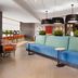Home2 Suites by Hilton Alexandria lobby with blue sectional sofa, pendant lights, and dining area