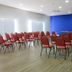 The World Indaiatuba meeting room with rows of red chairs and a blue accent wall