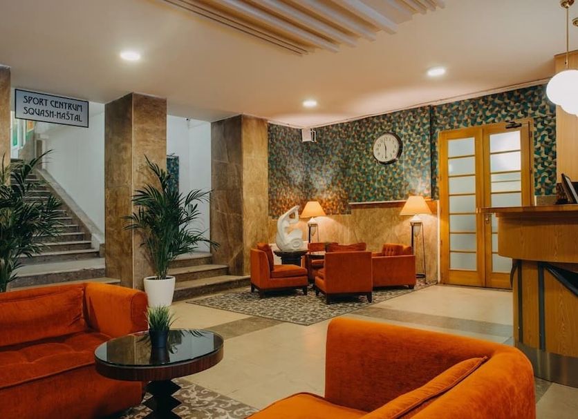 Metropolitan Old Town Hotel Prague lobby lounge with orange seating, plants and patterned walls